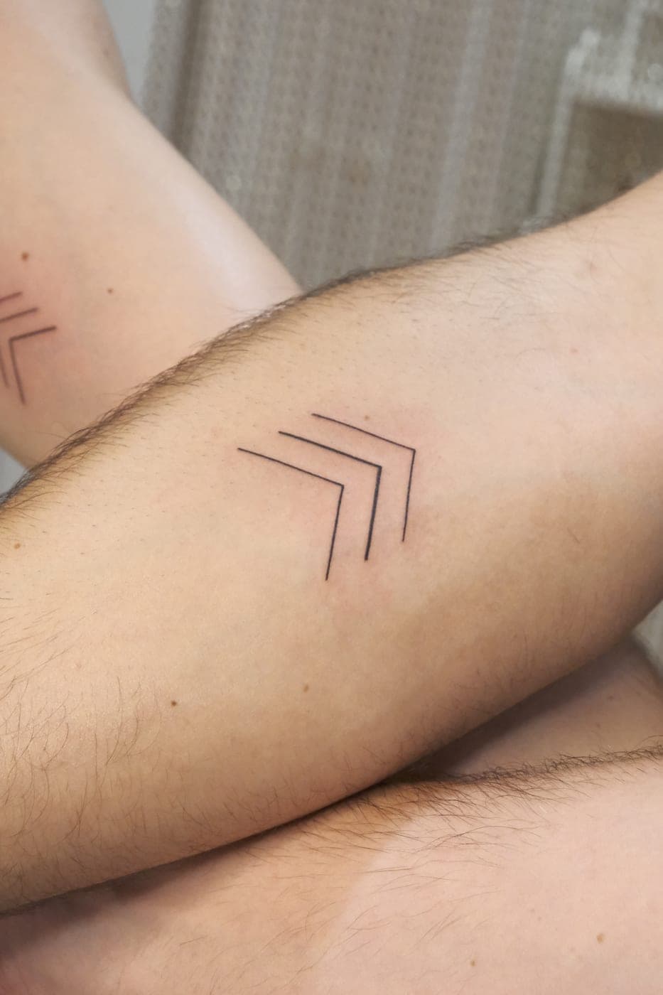 Tatuagens de setas a condizer em dois braços