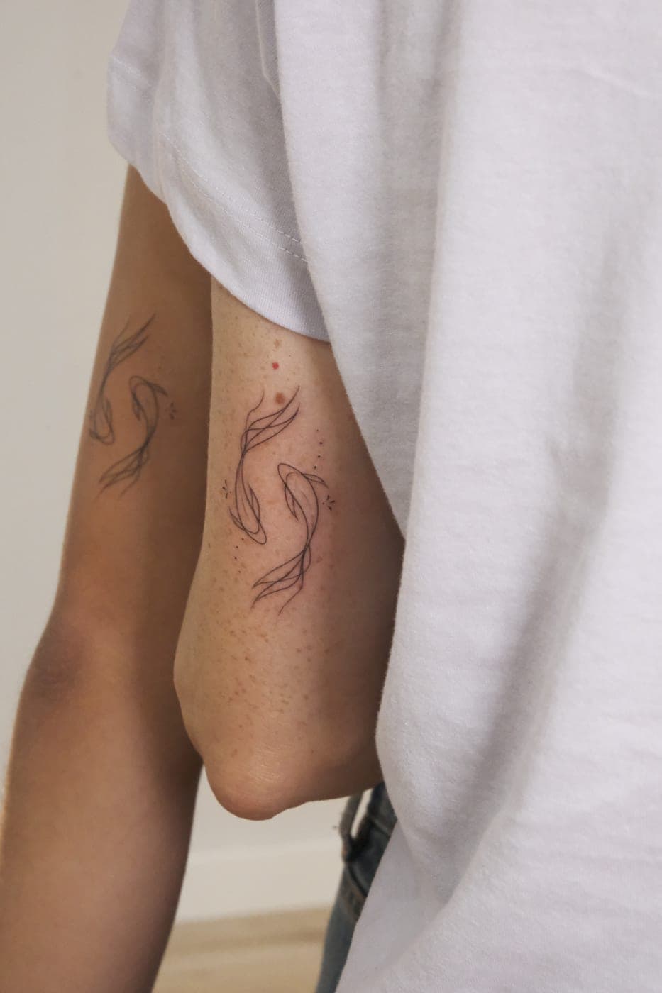 Dois peixes a condizer em dois braços