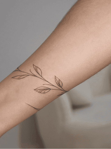 Ramo de folhas tatuado em fine line