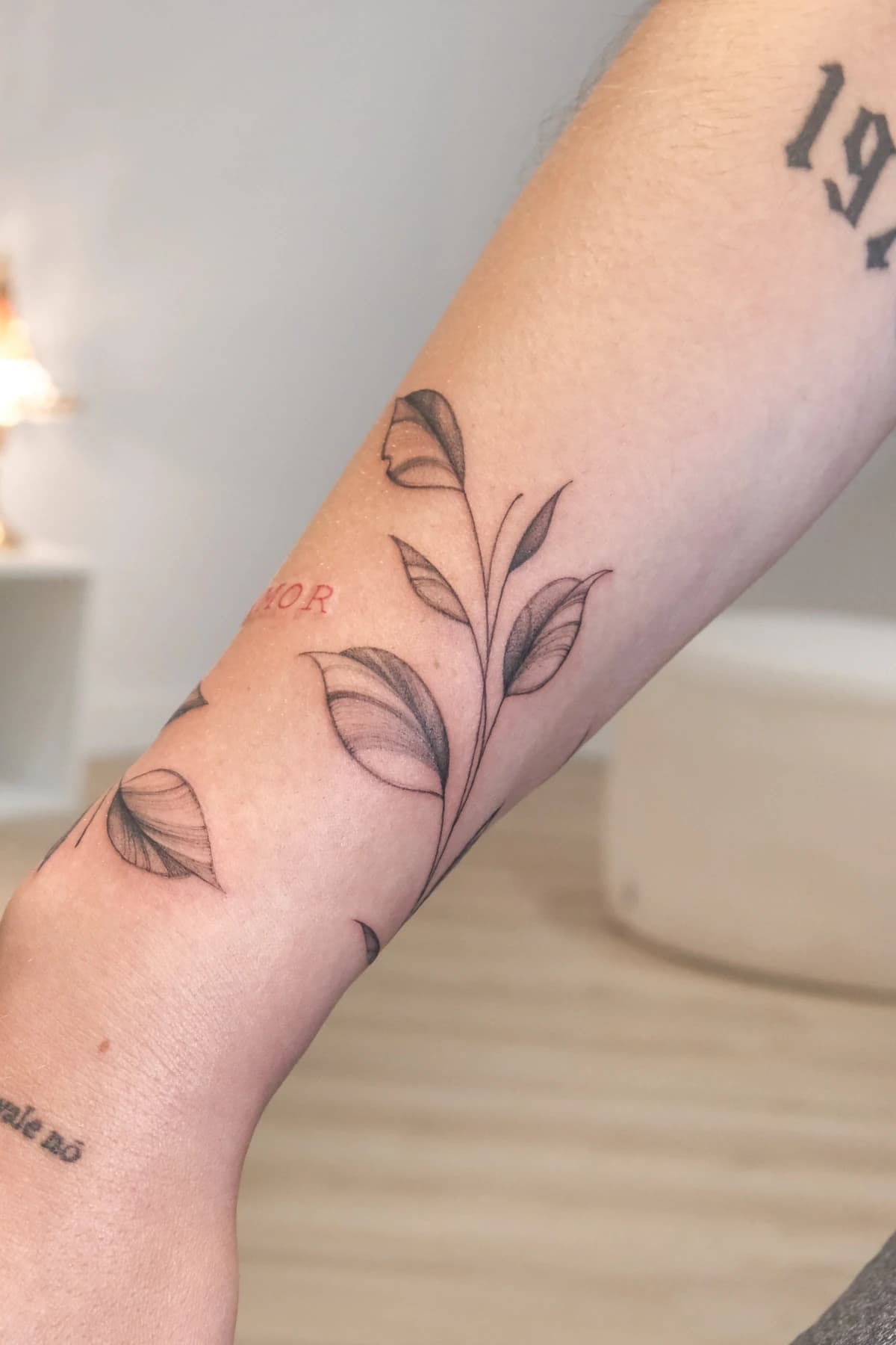 Ramo de folhas desenhado em fine line no antebraço